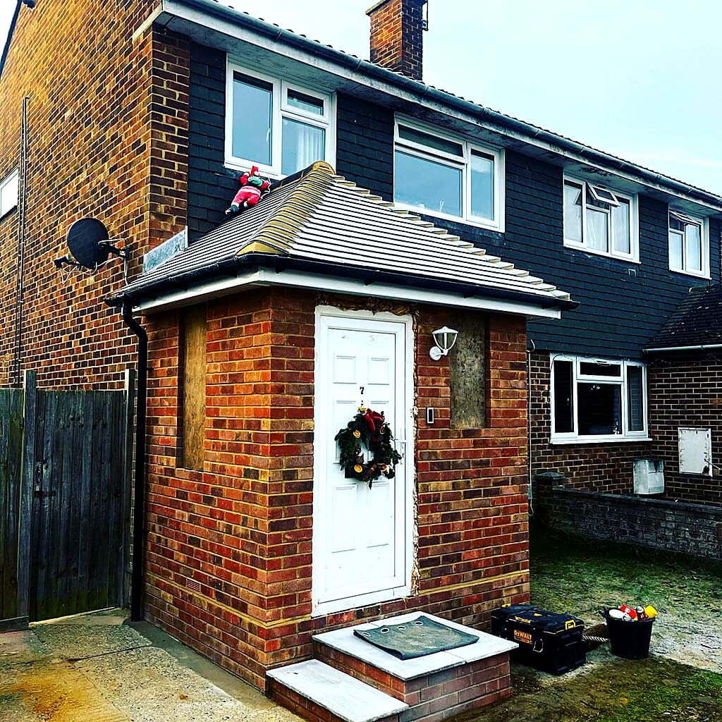 New brick porch with a tiled pitched roof, photographed before the windows went in